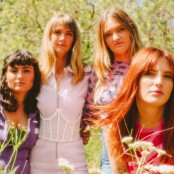 Four woman dressed in pink & purple in a field